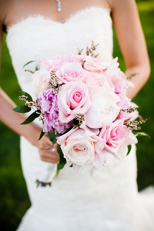 Bride holding light pink, peach, and purple floral bouquet - wedding photo by Michael Norwood Photography